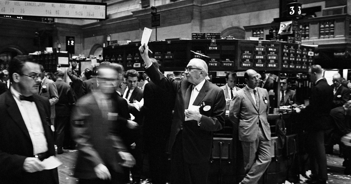 Modern stock exchange trading floor with multiple workstations and electronic display boards